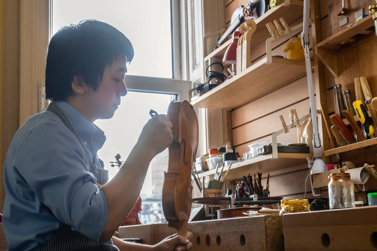 バイオリンにニスを塗る職人